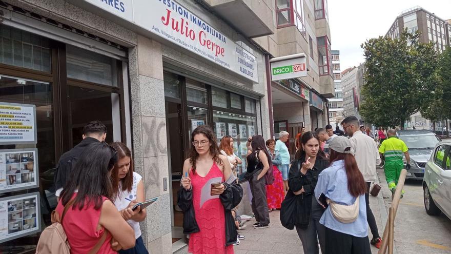 Jóvenes estudiantes aguardan su turno en la mañana de ayer ante una de las inmobiliarias de la capital gallega / X.A.