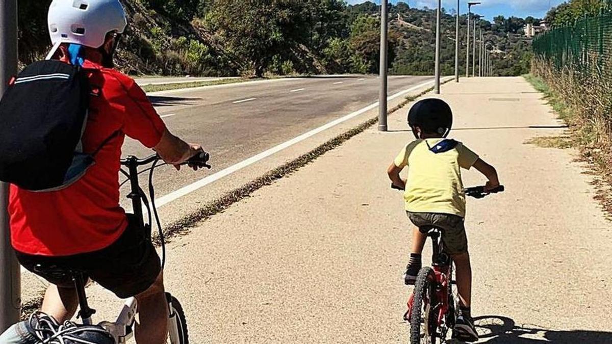 Un hombre y un niño circulan en bicicleta por un carril bici.