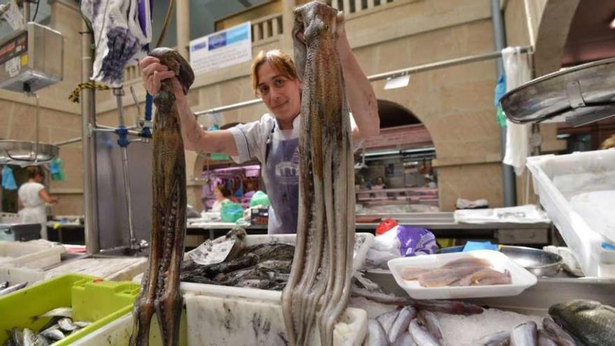 Una vendedora muestra algunos ejemplares en el Mercado de Pontevedra. // G. Santos