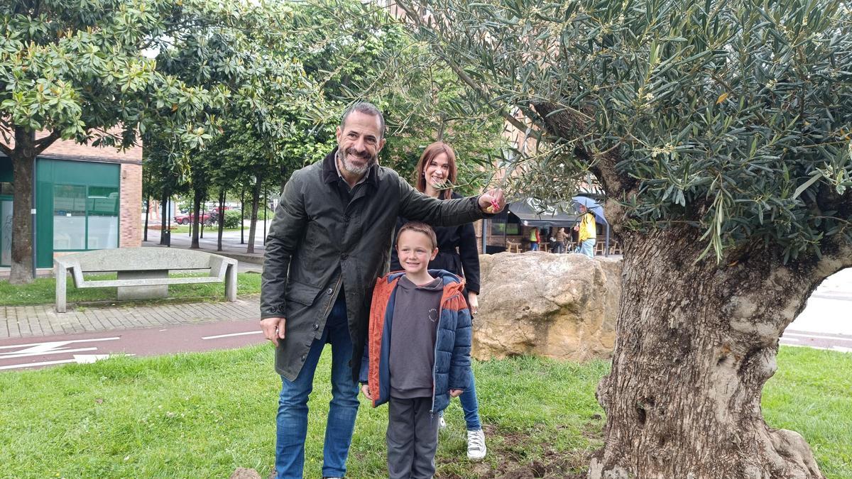 Martín Fernández cuelga el primer chupo en el Árbol de los Chupetes de Lugones, acompañado por Ángel García y María José Fernández.