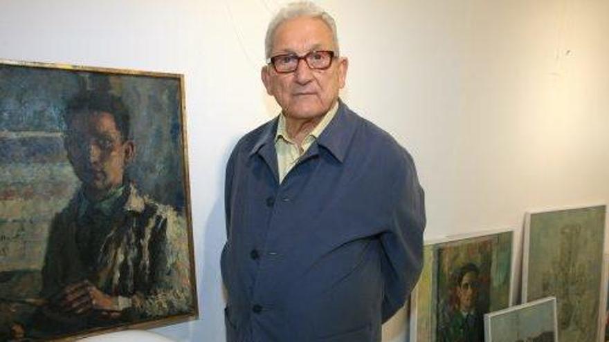 El pintor Carloandrés, junto a uno de sus autorretratos, en la exposición retrospectiva de 2011.