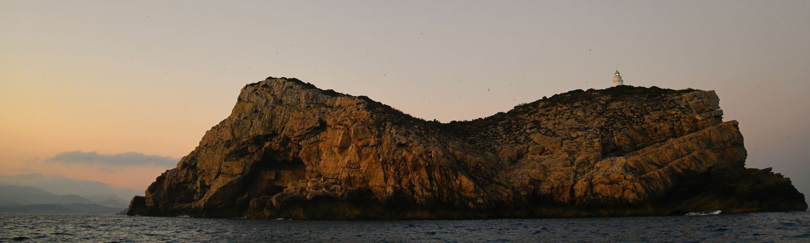 Claessens dona com a cosa certa que Anníbal va néixer a la Conillera de Sant Antoni de Portmany. Al fons, l&#039;illa de la Conillera, des del cap de sa Serra, vora la Bassa.