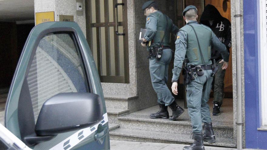 Uno de los detenidos ayer en Vigo, custodiado por dos agentes. // Ricardo Grobas