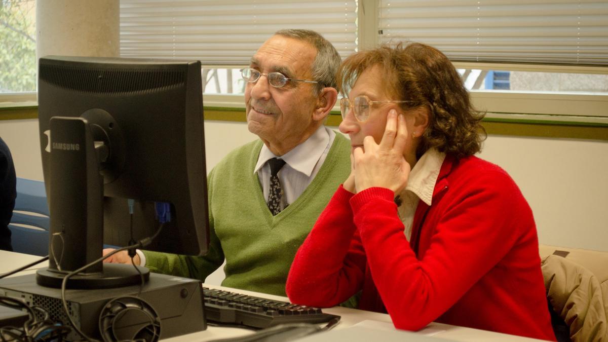 Archivo - Un hombre y una mujer mayores miran la pantalla de un ordenador.