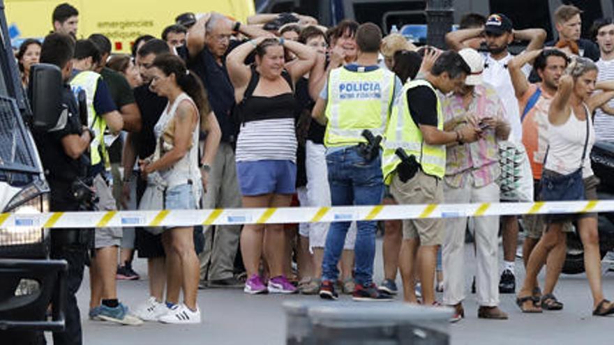 Decenas de turistas con los brazos en alto tras salir de los comercios en los que se refugiaron tras el atentado. EFE/Andreu Dalmau