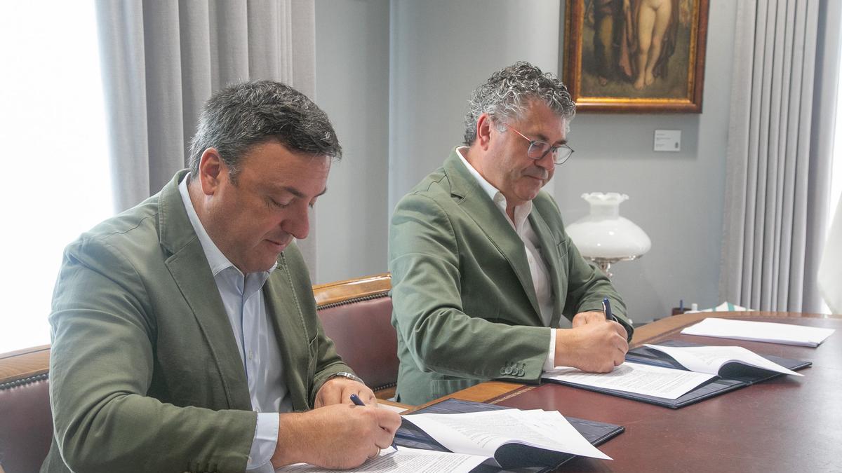 Valentín González á esquerda, presidente da Deputación, e Ovidio Rodeiro á dereita, alcalde de Boqueixón, firmando o acordo