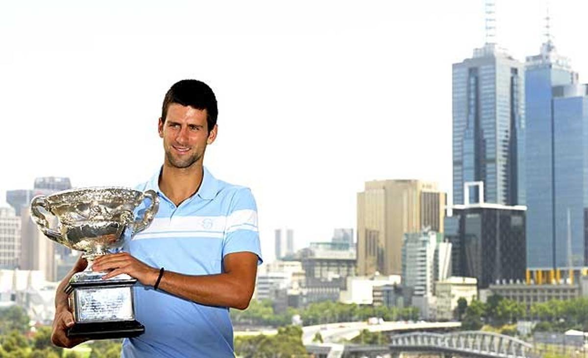 El tennista serbi Novak Djokovic somriu mentre agafa el seu trofeu de campió de l’Open d’Austràlia, durant una sessió fotogràfica a Melbourne.