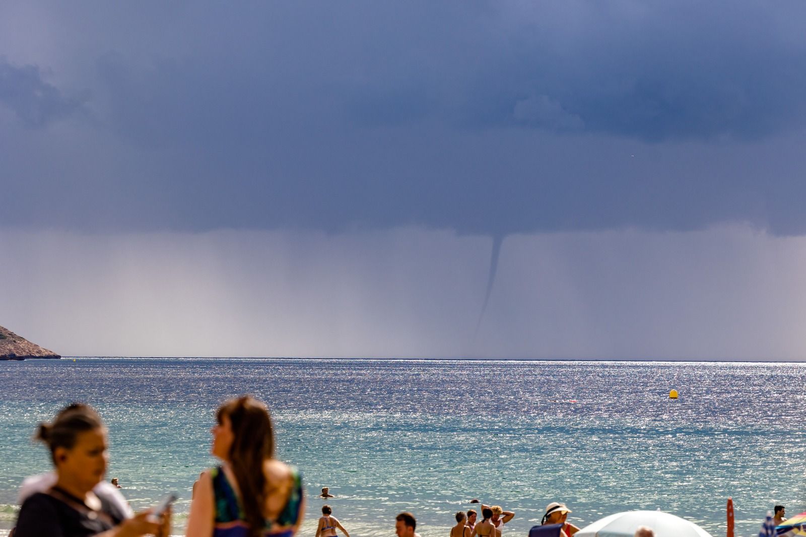 Los bañistas permanecen en las playas de Benidorm pese a la amenaza de lluvias