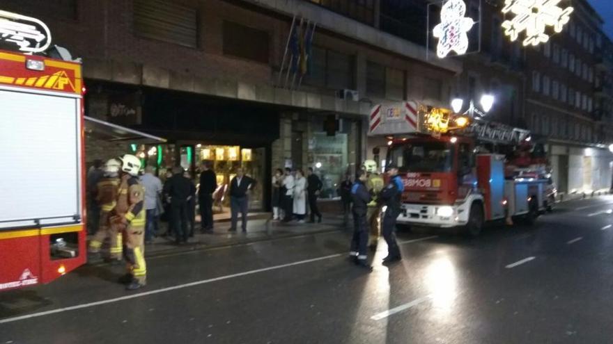 Bomberos y Policía Local, junto al local en el que se produjo el incendio.