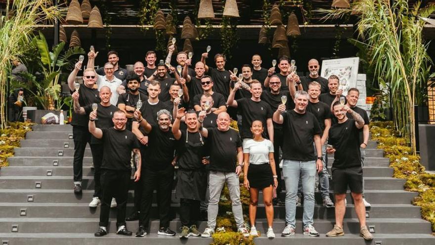 Los chefs Michelin y sus respectivos equipos posan en la escalera del restaurante de Oku. |