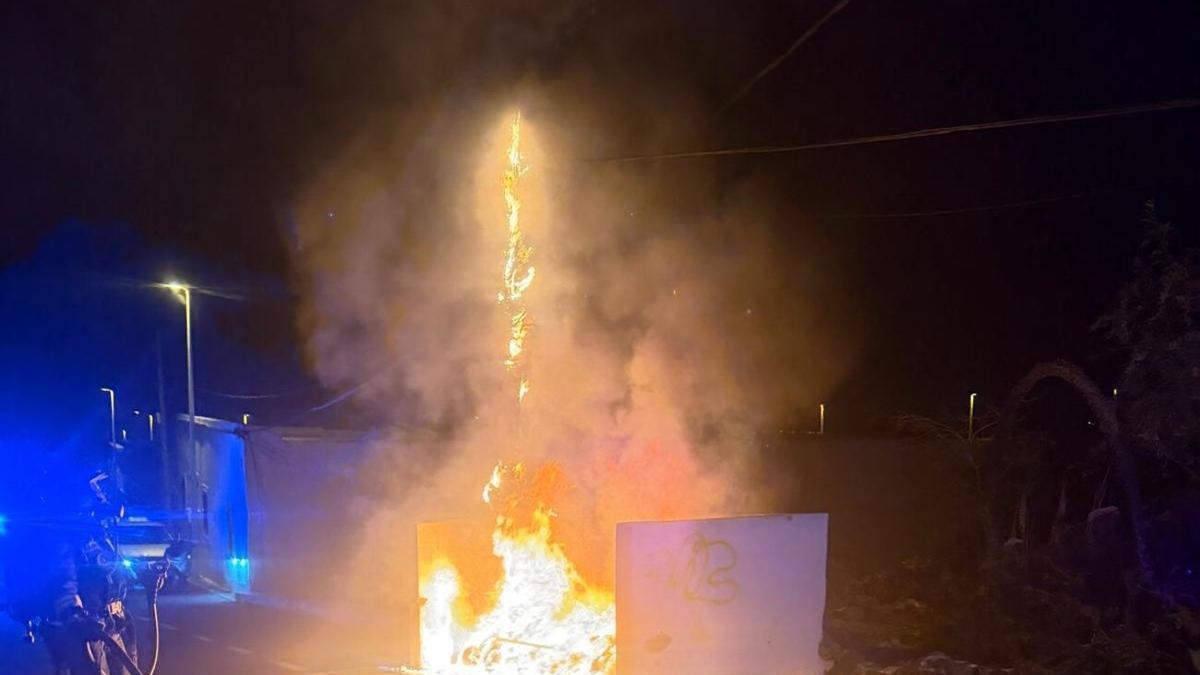 Contenedor de basura y poste de telefonía ardiendo durante la madrugada de este viernes en la calle José Calasanz, en San Bartolomé