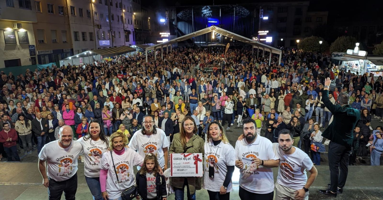 La afortunada posa con la comisión en el escenario y, al fondo, un lleno Campo da Feira.