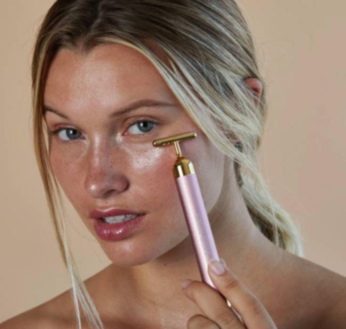 Chica usando el rodillo facial vibrador de Skin Gym
