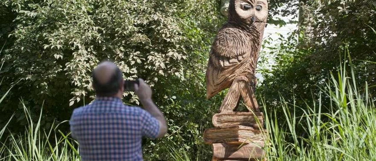 Un hombre fotografía el &quot;Moucho da sabedoría&quot;, la nueva escultura del campus. // Brais Lorenzo