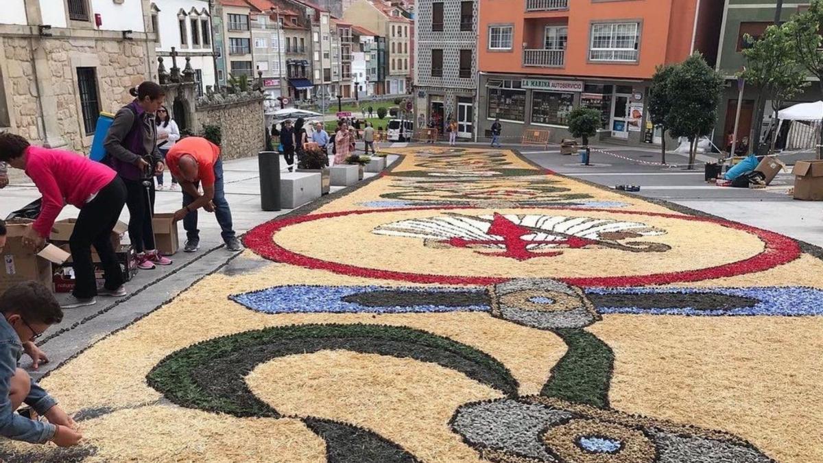 Los alfombristas realizan los últimos retoques al manto artístico en una calle de A Guarda, ayer. |   // FDV