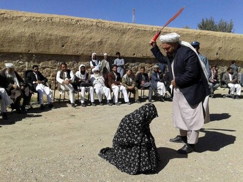 Afghan judge hits a woman with a whip in front of a crowd in Ghor province