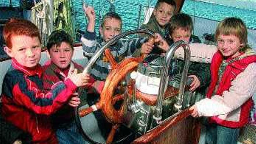 Un grupo de alumnos en el timón del barco Íbero. / j.l. oubiña