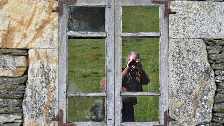 El fotógrafo reflejado en una de las casas de una aldea.