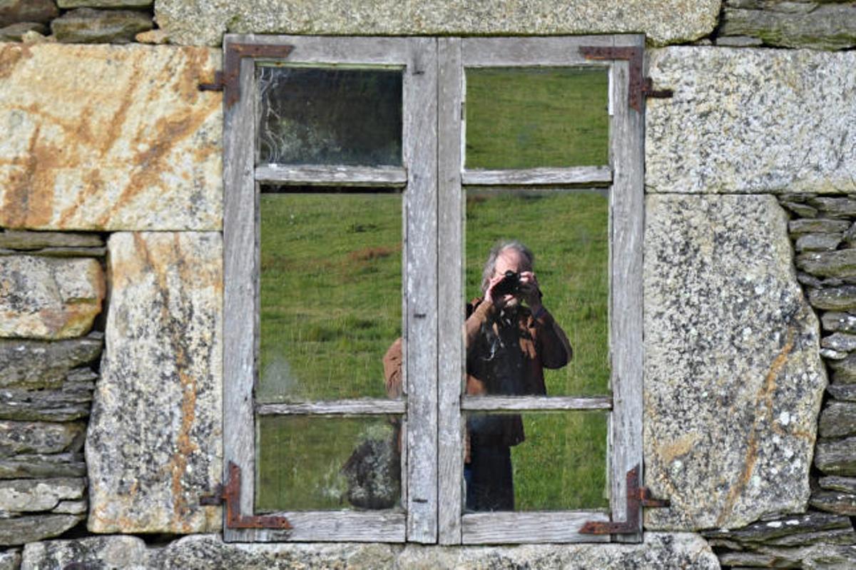 El fotógrafo reflejado en una de las casas de una aldea.