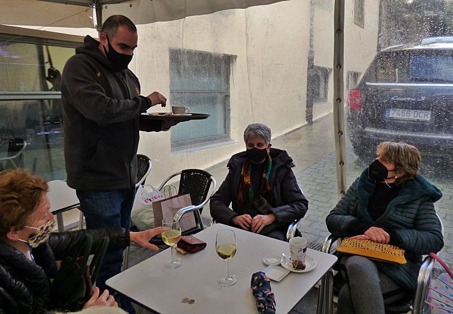 Marcos Gómez atiende a sus clientas Carmen Sierra, Marián Rodríguez y Carmen Álvarez en la terraza de su local. | D. Á.