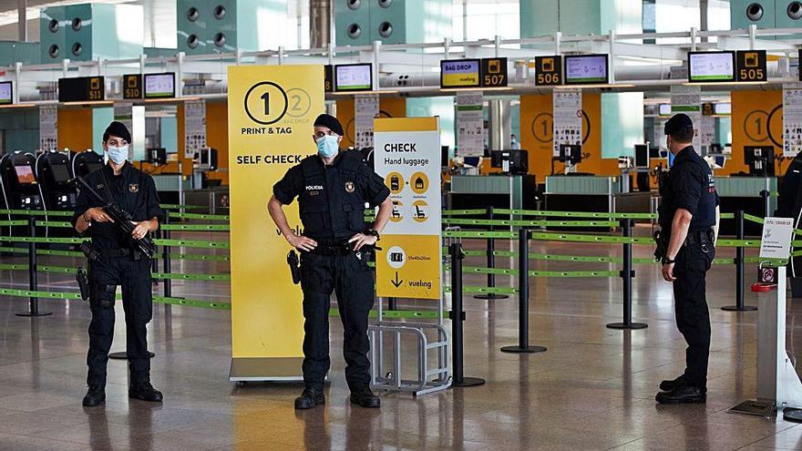 Tres agentes de policía, ayer en el aeropuerto de El Prat.