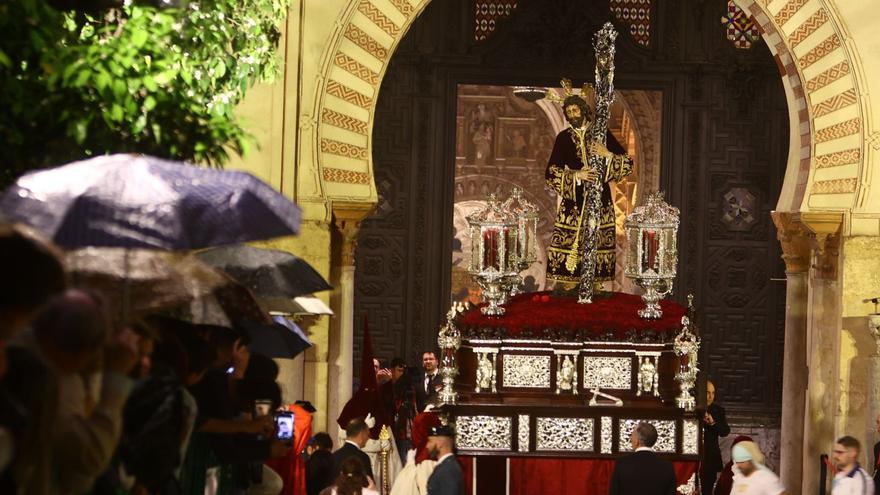 Nuestro Señor de los Reyes sale entre paraguas al Patio de los Naranjos de la Mezquita-Catedral, donde al final se refugió la hermandad de la Vera Cruz.