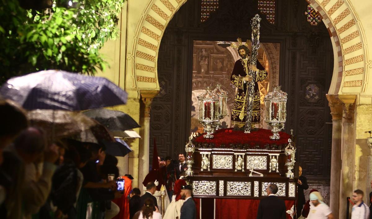 Nuestro Señor de los Reyes sale entre paraguas al Patio de los Naranjos de la Mezquita-Catedral, donde al final se refugió la hermandad de la Vera Cruz. | PABLO CABRERA