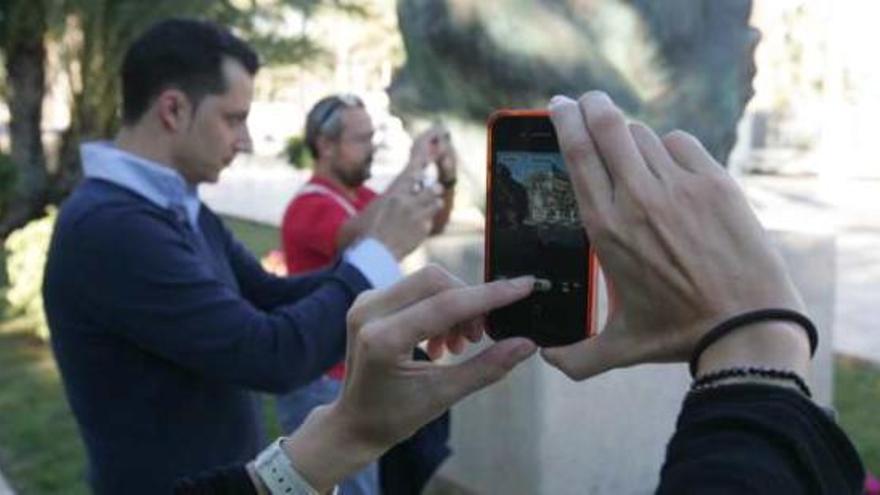 Participantes paseando por Elche mientras fotografiaban detalles y los compartían en sus redes.