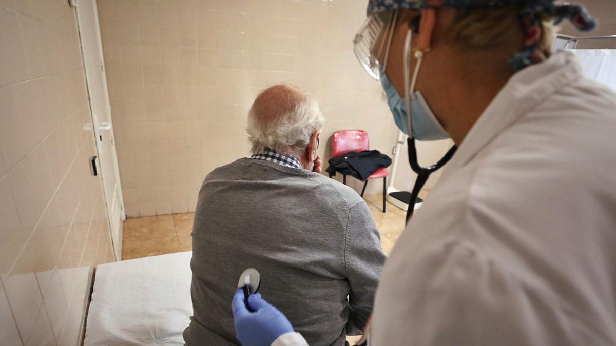 Una médico de familia ausculta a un paciente en su consulta. | ANTONIO AMORÓS
