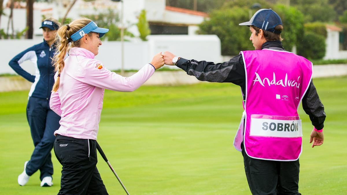 Luna Sobrón es felicitada por su caddie tras embocar una bola.