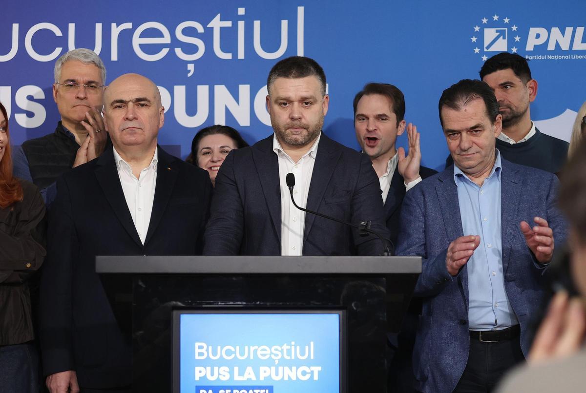 El candidato a la alcaldía respaldado por el Partido Nacional Liberal (PNL) y alcalde en funciones del Distrito 6 de Bucarest, Ciprian Ciucu (C), acompañado por el primer ministro rumano Ilie Bolojan (C-I), reacciona mientras es aplaudido por su equipo