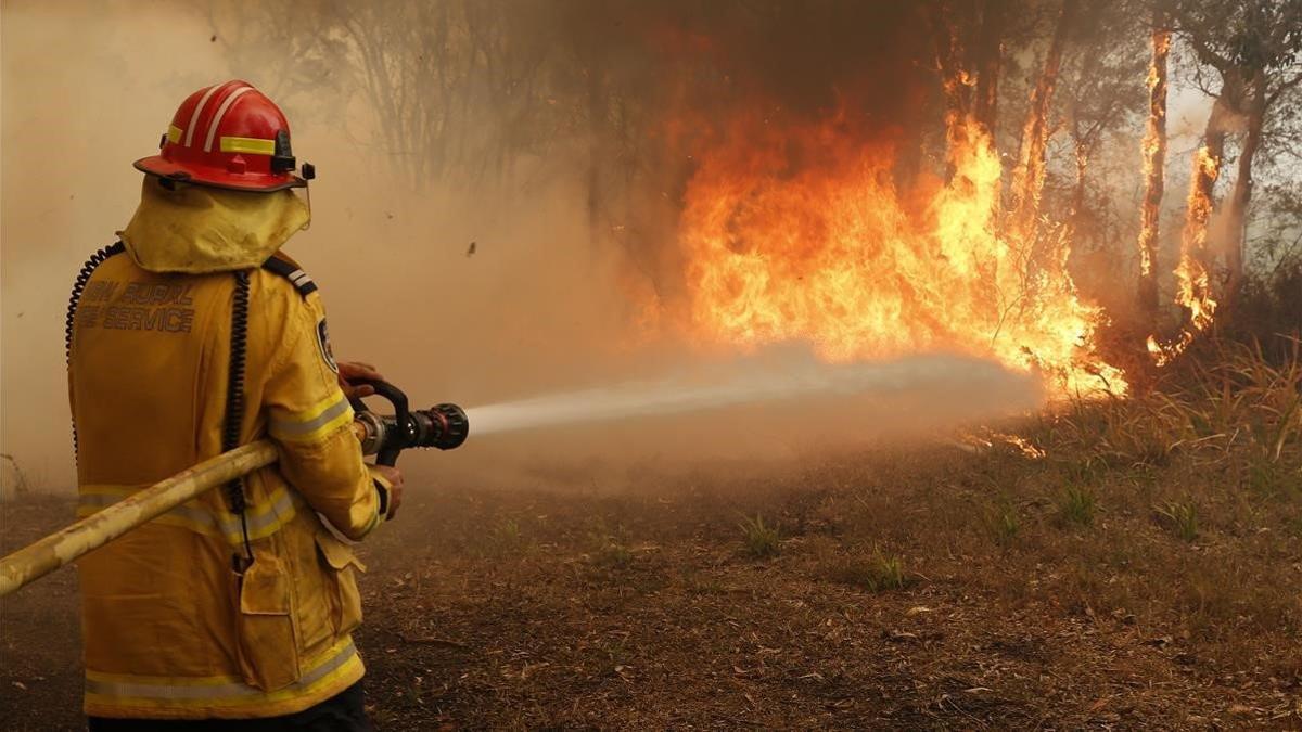 Un bombero trabaja en la extinción de un incendio forestal en los alrededores de Sídney, en Australia