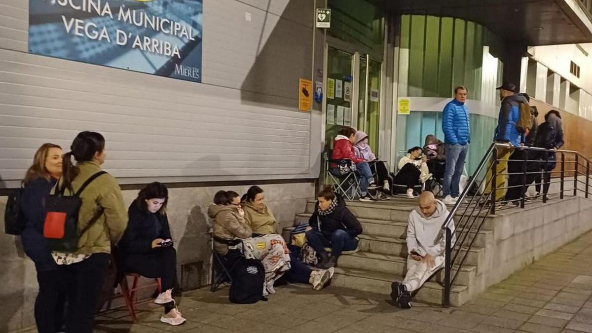 Familiares de los niños haciendo de madrugada en la entrada de la piscina de Vega de Arriba en Mieres. | P. Tuñón
