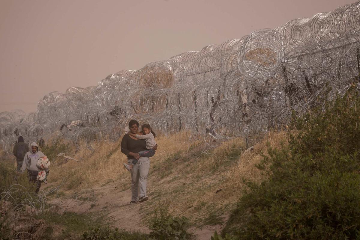 Migrantes acampan a lo largo de la orilla del río Grande mientras esperan entregarse a las autoridades de inmigración en El Paso, Texas, EE.UU