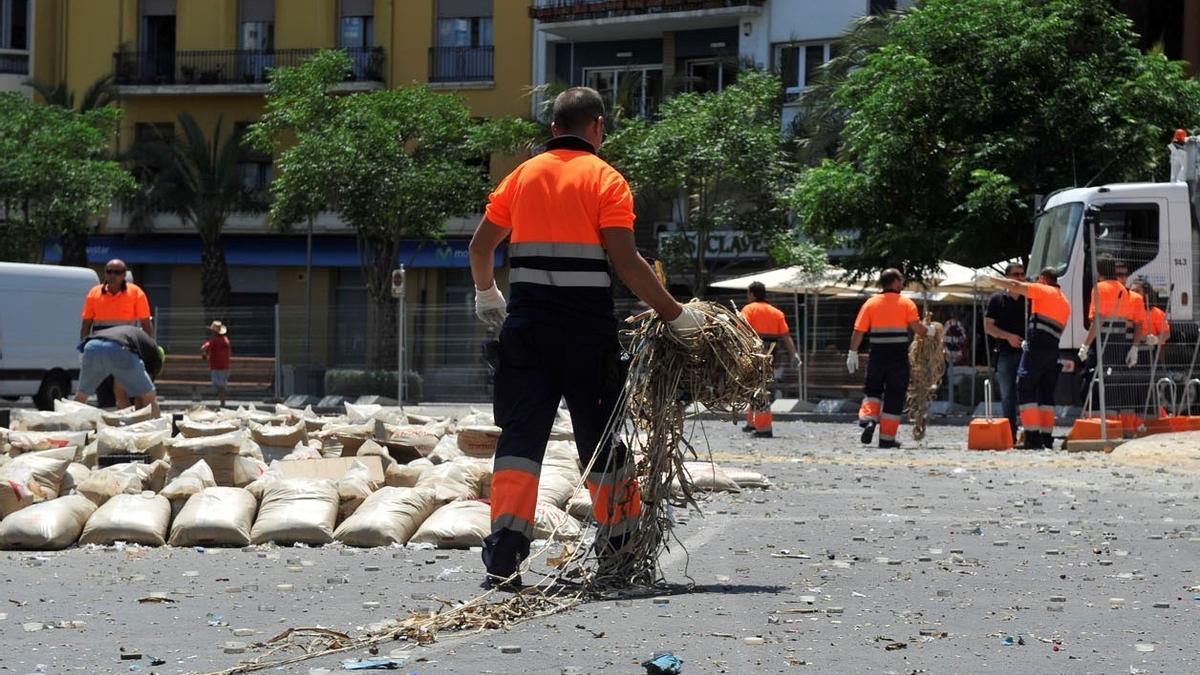 Varios operarios limpian en la plaza de los Luceros tras una mascletà.