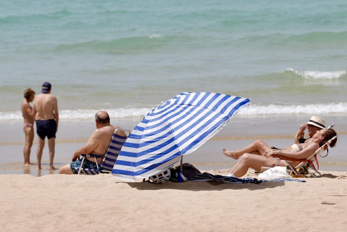 CHICLANA DE LA FRONTERA (CÁDIZ), 30/05/2025.- Varias personas descansan en la playa de Chiclana de la Frontera (Cádiz), este viernes con temperaturas extremas de hasta 40 grados en Andalucía inusual para el último fin de semana de mayo. EFE/Román Ríos