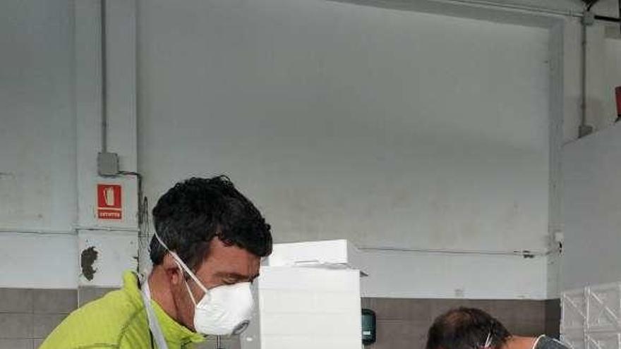 Manuel Fernández y Eduardo Martín, ayer, envasando ostras. T. Cascudo