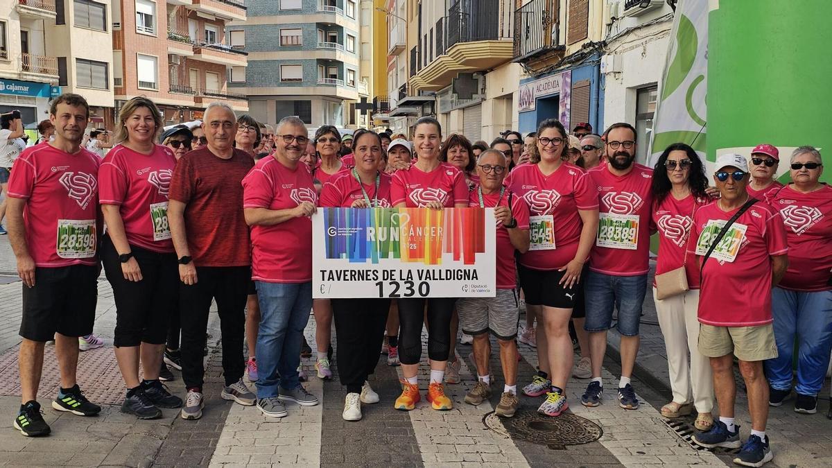 Autoridades y participantes exhiben el talón con el dinero recogido