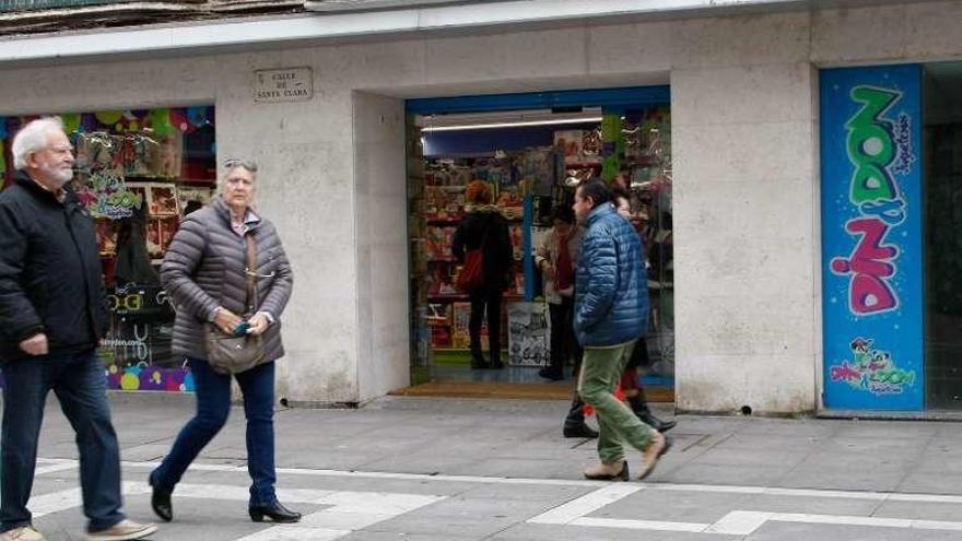 Viandantes pasean ante un comercio de Santa Clara.