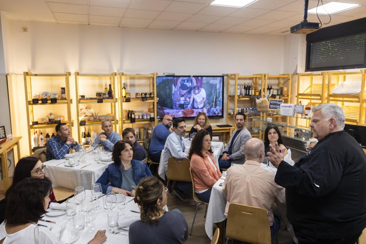 El professor Pascual Laza explicant a la Botiga de l’Aprenent en què va a consistir l'experiència culinària a les persones convidades a l'homenatge a l’esmorzar.