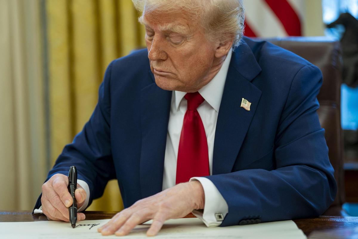 El presidente Trump firma una orden.