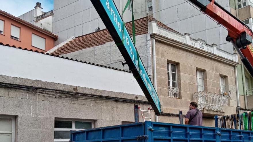 Trabajos para la retirada del cartel del PP en la antigua sede de la calle Concepción Arenal. |   // G.N.