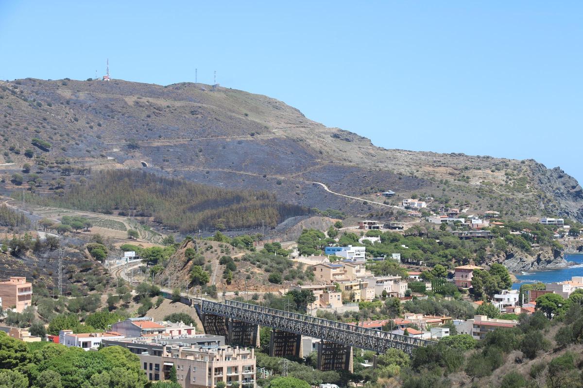 La imatge de Colera amb part de la muntanya cremada.