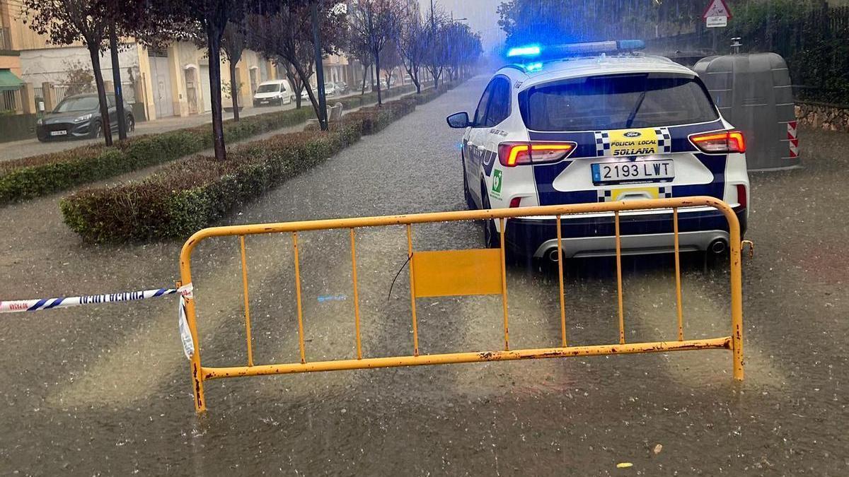 La Policía Local de Sollana corta una avenida del núcleo urbano anegada por el agua.