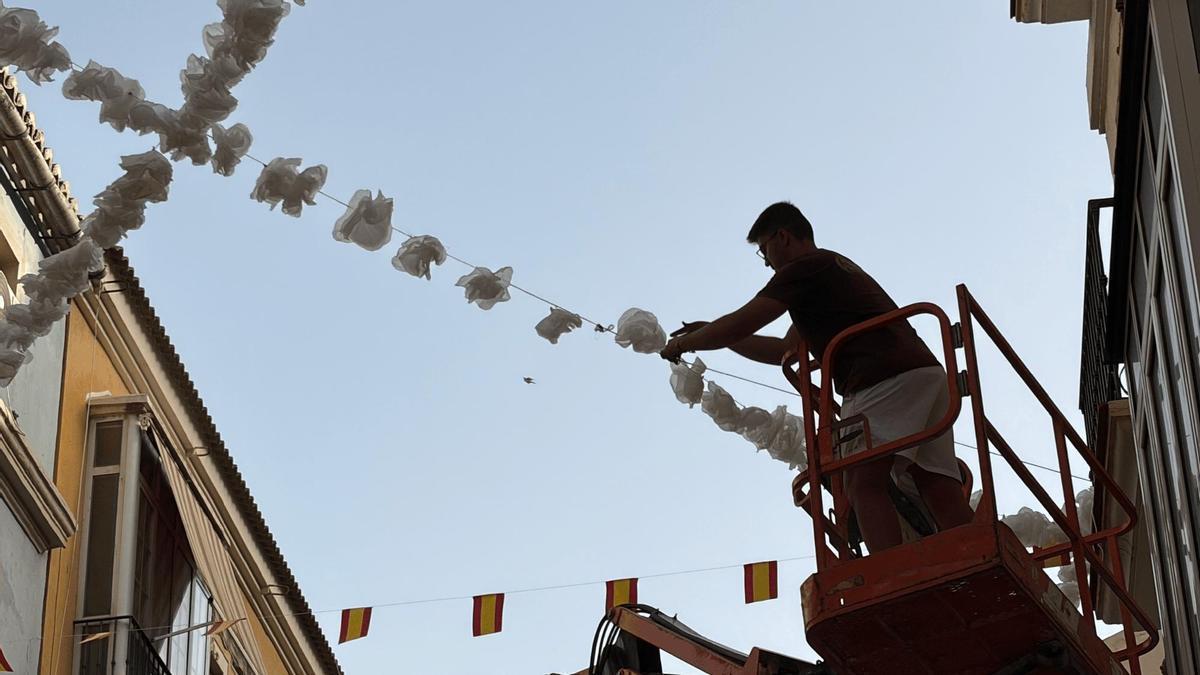 Colocación de girnarldas de flores en Calle Ancha