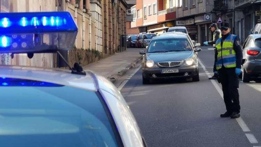 Control policial en la calle Jaime Janer de Marín para hacer cumplir el decreto de emergencia. // S.A.