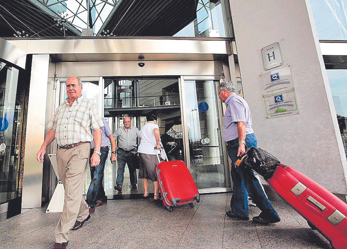 Turistas sénior en la entrada de un establecimiento hotelero.