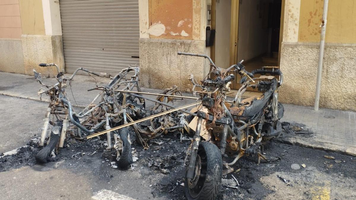 Las motos calcinadas, frente a la puerta del edificio.