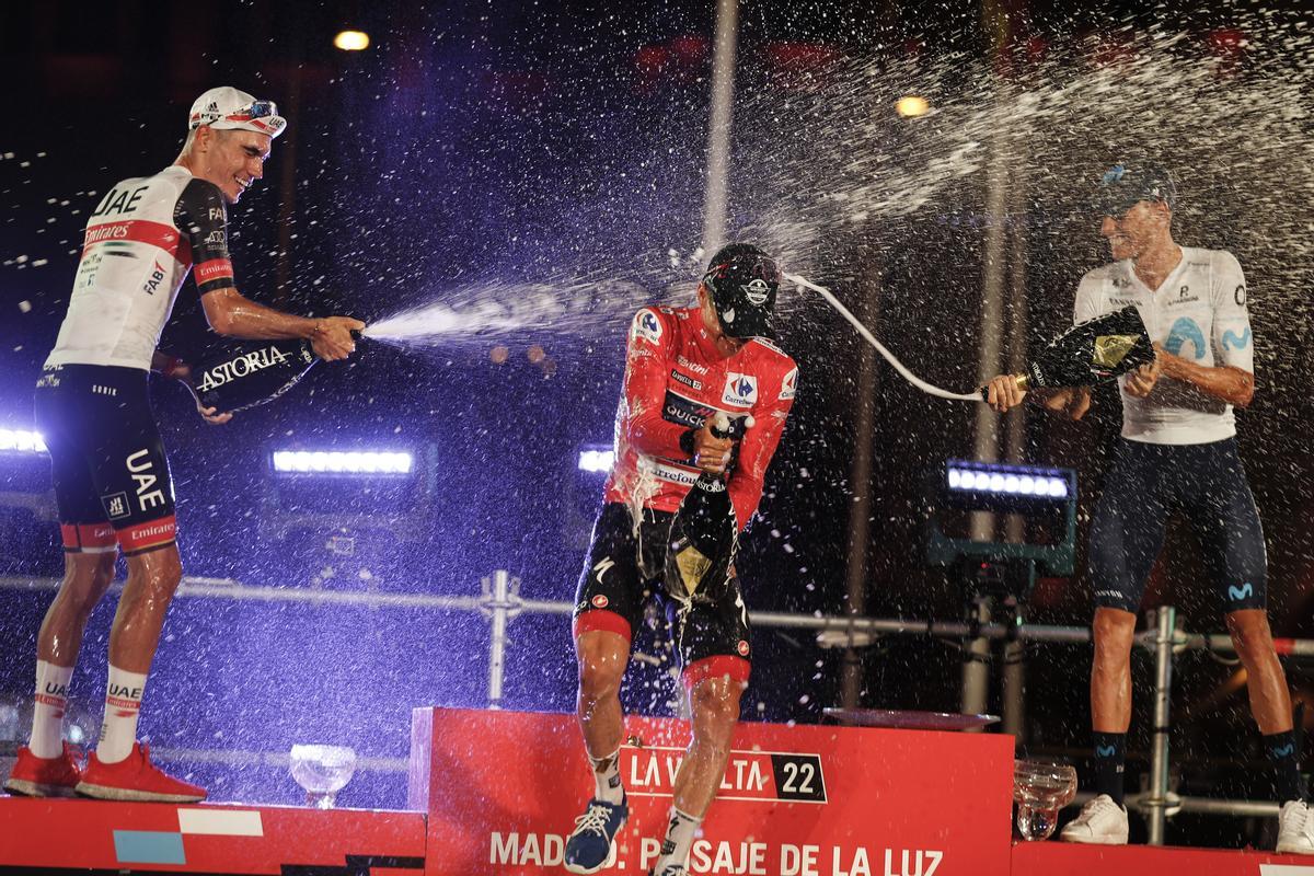 MADRID, 11/09/2022.- El belga Remco Evenepoel, ganador de la Vuelta, celebra la victoria en el podio junto a los españoles Enric Mas (Movistar) y Juan Ayuso (UAE Emirates), segundo y tercero, respectivamente, tras la etapa final de la 77 edición de la Vuelta Ciclista a España, este domingo en Madrid. EFE/ Javier Lizón