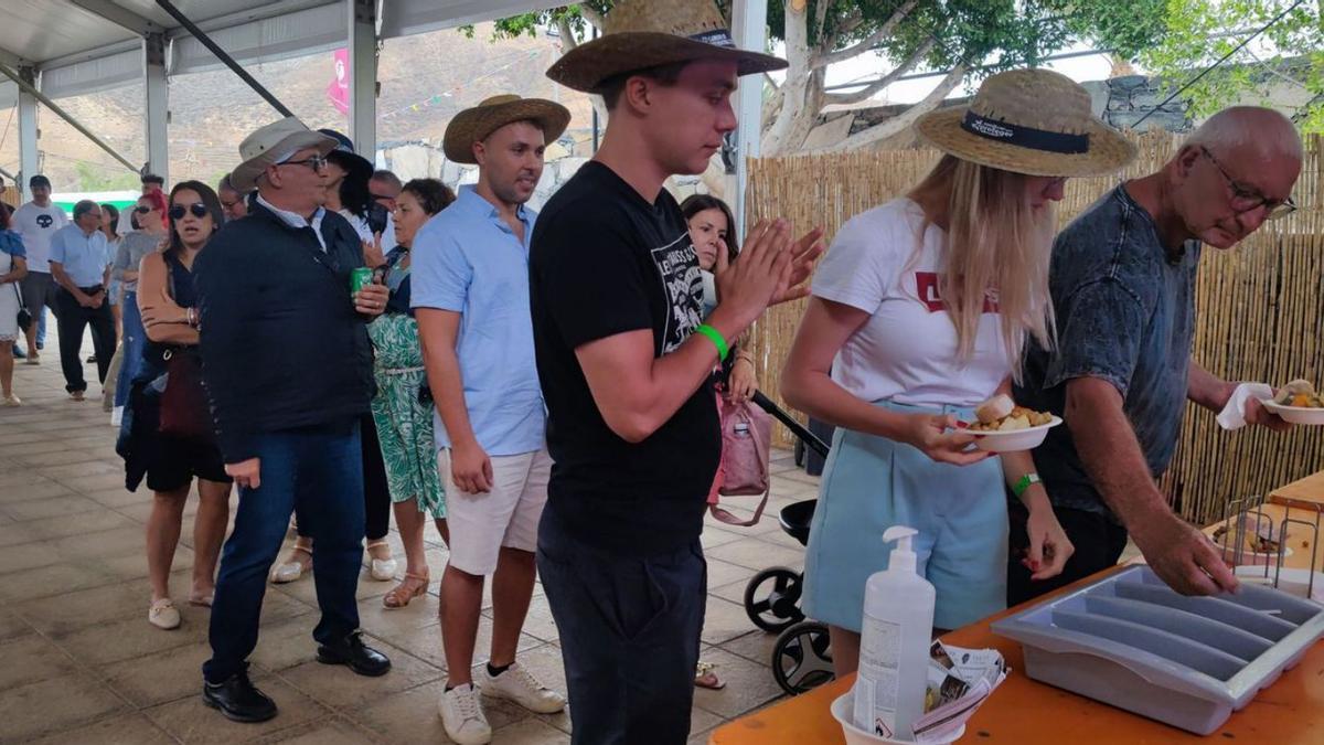 Vecinos hacen cola para degustar el puchero de la fiesta. | | ONDA FUERTEVENTURA